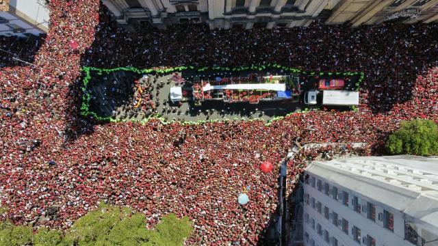 In this aerial view fans surround a bus carrying Flamengo's football team as it drives through Rio de Janeiro on November 30, 2025, a day after clinching the 2025 Copa Libertadores title. (Photo by Tercio Teixeira / AFP)