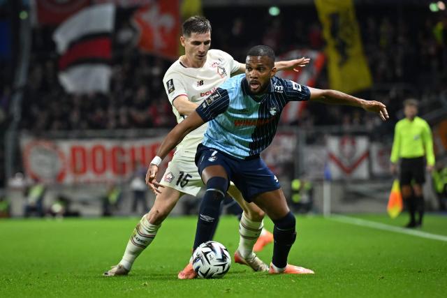 Lille's French defender #15 Romain Perraud (L) and Le Havre's Hungarian defender #07 Loic Nego fight for the ball during the French L1 football match between Le Havre AC and Lille LOSC at the Oceane stadium in Le Havre, north-western France, on November 30, 2025. (Photo by Lou BENOIST / AFP)