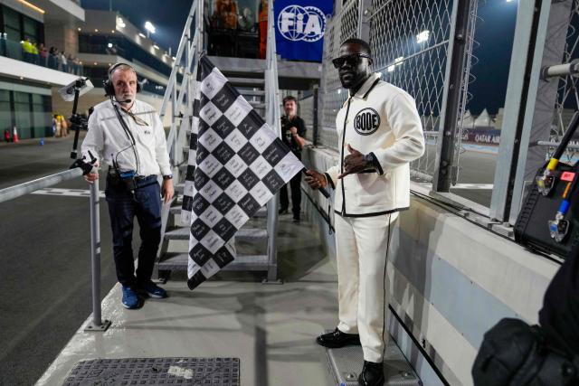 US actor Kevin Hart poses for a photo with the chequered flag during the Formula One Qatar Grand Prix at the Lusail International Circuit in Lusail on November 30, 2025. (Photo by Altaf Qadri / POOL / AFP)