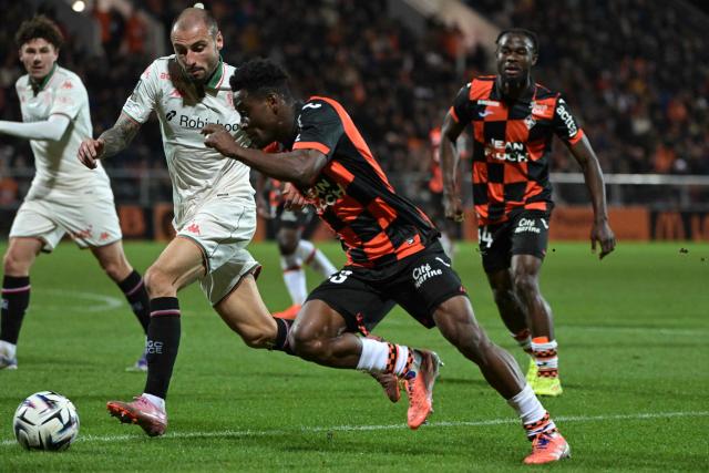 Lorient's Burkinabe defender #43 Arsene Kouassi (C-R) fights for the ball with Nice's French defender #92 Jonathan Clauss (C-L) during the French L1 football match between FC Lorient and OGC Nice at the Stade du Moustoir in Lorient, western France on November 30, 2025. (Photo by Damien Meyer / AFP)