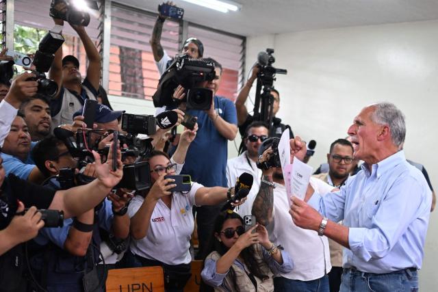 Honduras presidential candidate of the National Party Nasry Asfura shows his ballots to photographers before voting in Tegucigalpa on November 30, 2025. Hondurans voted for president on Sunday amid threats by US President Donald Trump to cut aid to the country if his preferred candidate loses. (Photo by MARVIN RECINOS / AFP)