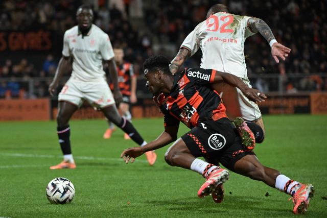 Lorient's Burkinabe defender #43 Arsene Kouassi (C) fights for the ball with Nice's French defender #92 Jonathan Clauss (R) during the French L1 football match between FC Lorient and OGC Nice at the Stade du Moustoir in Lorient, western France on November 30, 2025. (Photo by Damien Meyer / AFP)