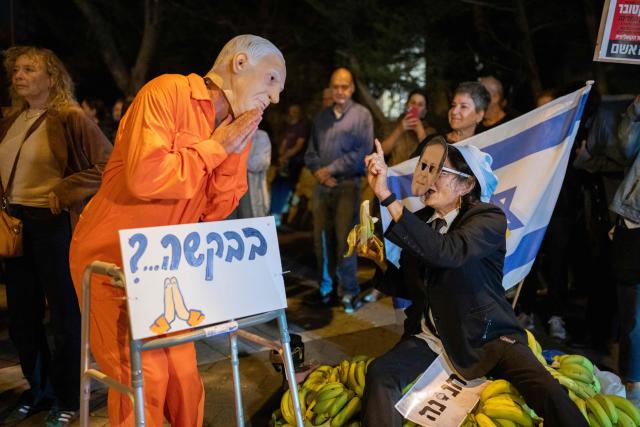 A demonstrator wearing a mask depicting Israeli Prime Minister Benjamin Netanyahu takes part in a protest outside the home of Israeli President Isaac Herzog in Tel Aviv following Netanyahu's request for a presidential pardon on November 30, 2025. Israeli Prime Minister Benjamin Netanyahu, on trial facing corruption charges, announced on November 30 he had submitted a pardon request, saying the long-running cases were tearing the country apart. US President Donald Trump wrote to Israeli President Isaac Herzog earlier this month, asking him to pardon Netanyahu, who has repeatedly denied wrongdoing in the proceedings. (Photo by Maya Levin / AFP)