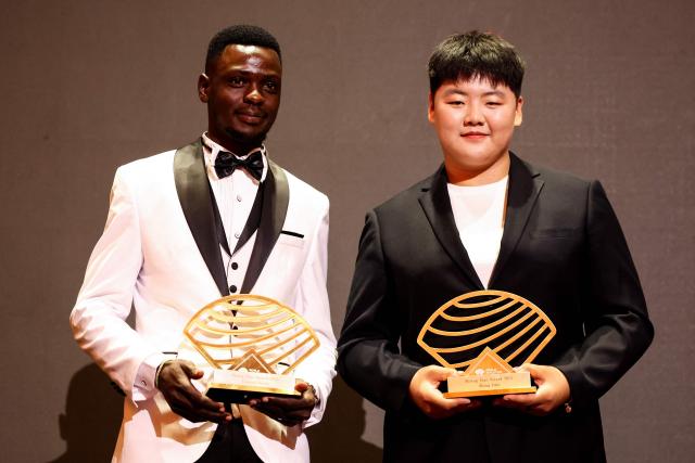 Male and female rising star award winners Kenya's long distance and steeplechase athlete Edmund Serem (L) and China's hammer throw athlete Zhang Jiale (R) pose during the World Athletics Awards 2025 in Monaco, on November 30, 2025. (Photo by Valery HACHE / AFP)
