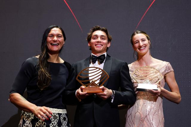 Sweden's world pole vault champion Armand Duplantis (C) holds his Men’s field athlete of the year award and Australia's world high jump champion Nicola Olyslagers (R) holds her Women’s field athlete of the year award as they pose on stage during the World Athletics Awards 2025 in Monaco, on November 30, 2025. (Photo by Valery HACHE / AFP)