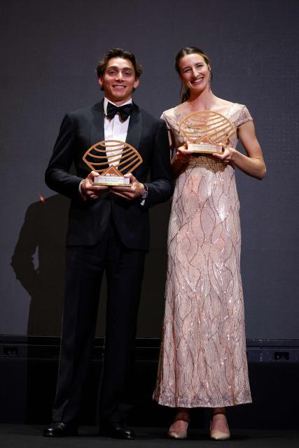 Sweden's world pole vault champion Armand Duplantis (L) holds his Men’s field athlete of the year award and Australia's world high jump champion Nicola Olyslagers (R) holds her Women’s field athlete of the year award as they pose on stage during the World Athletics Awards 2025 in Monaco, on November 30, 2025. (Photo by Valery HACHE / AFP)