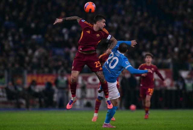 Roma's Italian defender #23 Gianluca Mancini heads the ball with Napoli's Macedonian midfielder #20 Eljif Elmas during the Italian Serie A football match between AS Roma and Napoli at the Olympic Stadium in Rome on November 30, 2025. (Photo by Tiziana FABI / AFP)