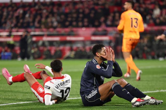 Real Madrid's English midfielder #05 Jude Bellingham (R) reacts next to Girona's Brazilian defender #12 Vitor de Oliveira during the Spanish league football match between Girona FC and Real Madrid CF at Montilivi Stadium in Girona on November 30, 2025. (Photo by Josep LAGO / AFP)