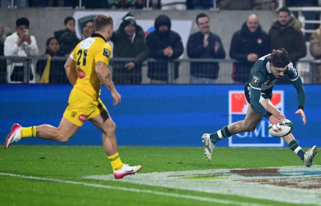 Pau's French wing Gregoire Arfeuil (R) scores a try  during the French Top 14 rugby union match between Section Paloise Bearn Pyrenees (Pau) and Stade Rochelais (La Rochelle) at Stade du Hameau in Pau, south-western France on November 30, 2025. (Photo by Gaizka IROZ / AFP)