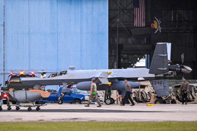 US military personnel work around an Air Force MQ-9 Reaper drone at Rafael Hernandez Airport in Aguadilla, Puerto Rico, on November 30, 2025. In recent weeks, US President Donald Trump has deployed warships, fighter jets and thousands of soldiers to Latin America and launched strikes on 21 alleged drug-smuggling boats, killing at least 80 people. (Photo by Miguel J. Rodriguez Carrillo / AFP)