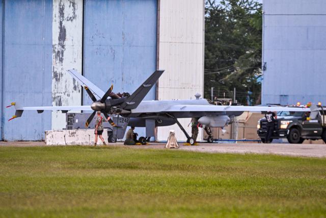 US military personnel work on an Air Force MQ-9 Reaper drone at Rafael Hernandez Airport in Aguadilla, Puerto Rico, on November 30, 2025. In recent weeks, US President Donald Trump has deployed warships, fighter jets and thousands of soldiers to Latin America and launched strikes on 21 alleged drug-smuggling boats, killing at least 80 people. (Photo by Miguel J. Rodriguez Carrillo / AFP)