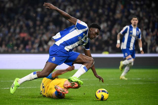 FC Porto's Spanish forward #09 Samuel Omorodion (TOP) fights for the ball with Estoril's Austrian defender #25 Felix Bacher during the Portuguese League football match between FC Porto and GD Estoril Praia at Dragao stadium in Porto on November 30, 2025. (Photo by Miguel RIOPA / AFP)