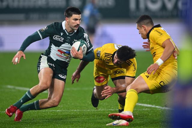 Pau's Australian fullback Jack Maddocks (L) runs with the ball during the French Top 14 rugby union match between Section Paloise Bearn Pyrenees (Pau) and Stade Rochelais (La Rochelle) at Stade du Hameau in Pau, south-western France on November 30, 2025. (Photo by Gaizka IROZ / AFP)