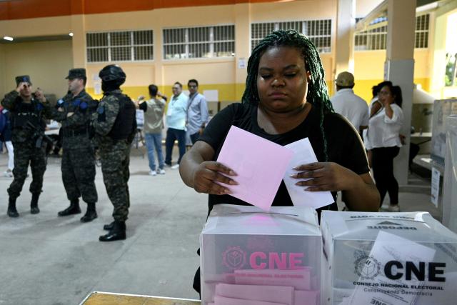 A woman casts her vote during Honduras' general election at a polling station in Tegucigalpa on November 30, 2025. Hondurans voted for president on November 30, 2025, amid threats by US President Donald Trump to cut aid to the country if his preferred candidate loses. (Photo by Orlando SIERRA / AFP)