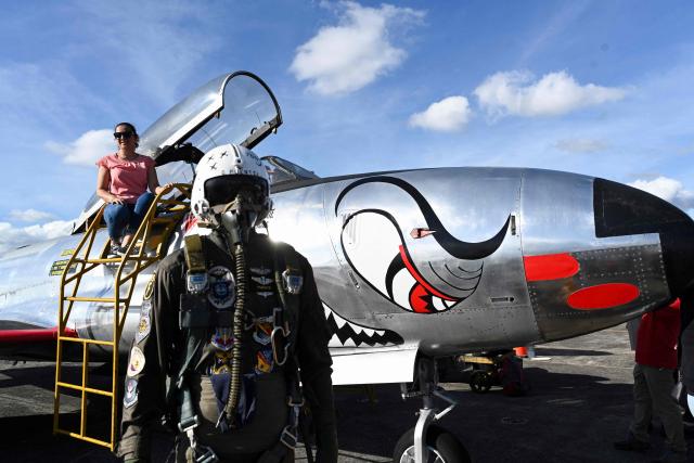 A woman poses for pictures next to a Guatemalan Army plane during 'Open base 2025' at the Guatemalan Air Force Base in Guatemala City on November 30, 2025. (Photo by Johan ORDONEZ / AFP)