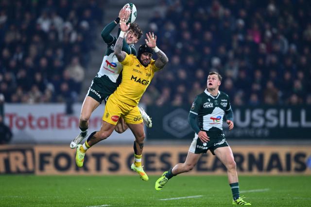 Pau's French wing Gregoire Arfeuil (L) and La Rochelle's English wing Jack Nowell (C) jump to grab the ball during the French Top 14 rugby union match between Section Paloise Bearn Pyrenees (Pau) and Stade Rochelais (La Rochelle) at Stade du Hameau in Pau, south-western France on November 30, 2025. (Photo by Gaizka IROZ / AFP)
