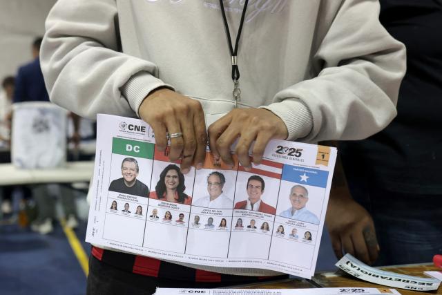 An election official holds an unmarked ballot after the closing of the polling stations during Honduras' general election in Tegucigalpa on November 30, 2025. Hondurans voted for president on November 30, 2025, amid threats by US President Donald Trump to cut aid to the country if his preferred candidate loses. (Photo by Lucas AGUAYO / AFP)
