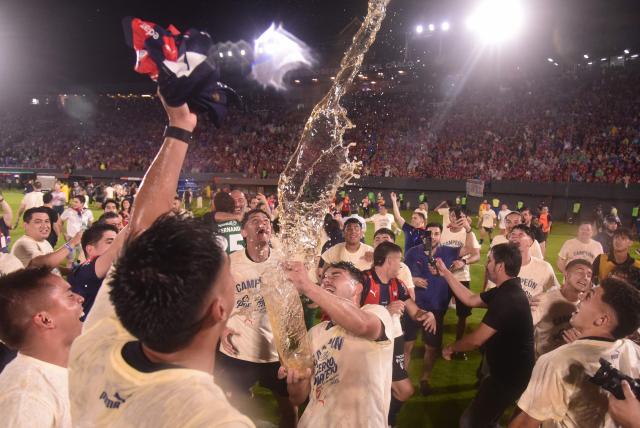 Cerro Porteno's Uruguayan midfielder #02 Fabricio Dominguez celebrates with the trophy after winning the Paraguayan first division Clausura football match between Cerro Porteno and Tembetary at Defensores del Chaco stadium in Asuncion on November 30, 2025. (Photo by DANIEL DUARTE / AFP)