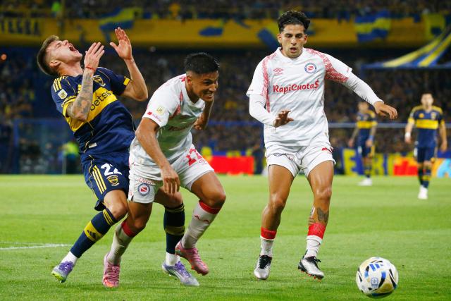 Boca Juniors' midfielder #22 Kevin Zenon (L) reacts after being hit by Argentinos Juniors' defender #22 Leandro Lozano (C) during the Argentine Professional Football League 2025 Clausura Tournament quarter-final match between Boca Juniors and Argentinos Juniors at La Bombonera Stadium in Buenos Aires on November 30, 2025. (Photo by Marcos BRINDICCI / AFP)