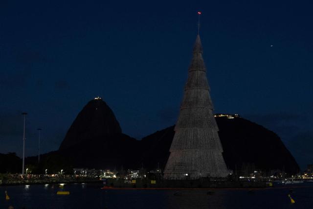 A floating Christmas tree is pictured in front of the iconic Sugarloaf Mountain at Botafogo waterfront in Rio de Janeiro, Brazil on November 30, 2025. (Photo by Pablo PORCIUNCULA / AFP)