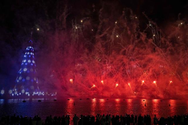 People enjoy a fireworks display next to a floating Christmas tree at Botafogo waterfront in Rio de Janeiro, Brazil on November 30, 2025. (Photo by Pablo PORCIUNCULA / AFP)