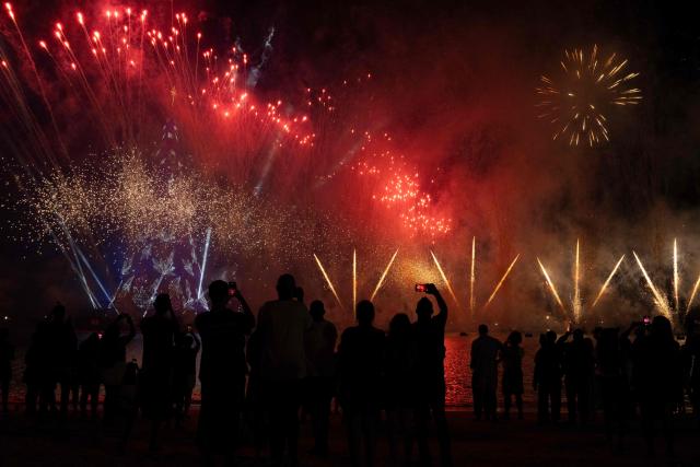 People enjoy a fireworks display next to a floating Christmas tree at Botafogo waterfront in Rio de Janeiro, Brazil on November 30, 2025. (Photo by Pablo PORCIUNCULA / AFP)