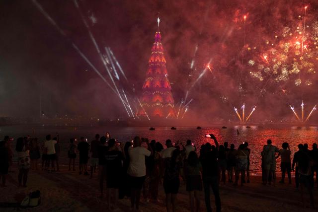 People enjoy a fireworks display next to a floating Christmas tree at Botafogo waterfront in Rio de Janeiro, Brazil on November 30, 2025. (Photo by Pablo PORCIUNCULA / AFP)
