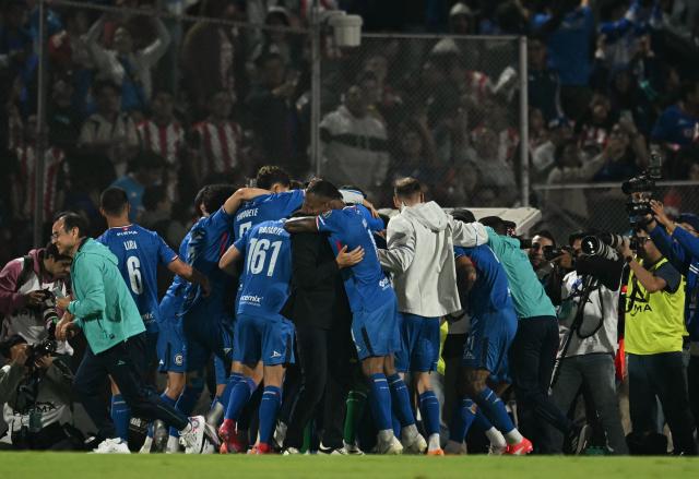 Cruz Azul players celebrate a last minute winning goal during the Liga MX Apertura quarter-final second leg football match between Cruz Azul and Guadalajara at the Olimpico Universitario Stadium in Mexico City on November 30, 2025. (Photo by YURI CORTEZ / AFP)
