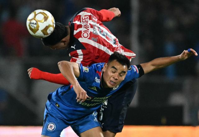 Guadalajara's defender #05 Bryan Gonzalez and Cruz Azul's midfielder #19 Carlos Rodriguez fight for the ball during the Liga MX Apertura quarter-final second leg football match between Cruz Azul and Guadalajara at the Olimpico Universitario Stadium in Mexico City on November 30, 2025. (Photo by YURI CORTEZ / AFP)