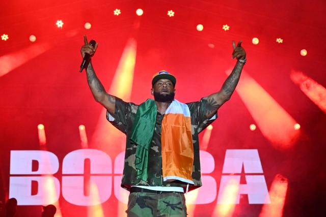 (FILES) French Rapper Elie Yaffa Booba performs at the 15th Festival of Urban Music of Anoumabo in Abidjan, on April 30, 2023. Booba's trial for racist insults and cyberbullying against two journalists will take place in Paris on December 3, 2025. (Photo by Issouf SANOGO / AFP)