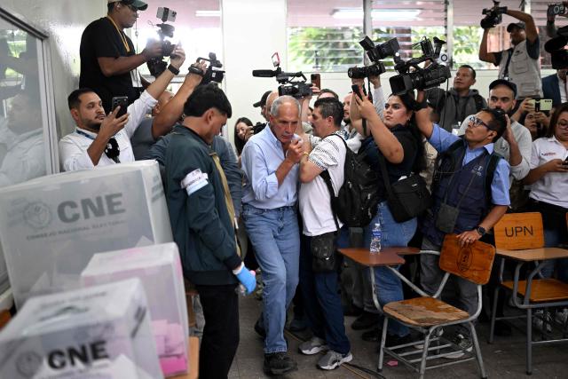 Honduras presidential candidate of the National Party Nasry Asfura walks among journalists as he casts his vote in Tegucigalpa on November 30, 2025. Hondurans voted for president on November 30, 2025, amid threats by US President Donald Trump to cut aid to the country if his preferred candidate loses. (Photo by MARVIN RECINOS / AFP)