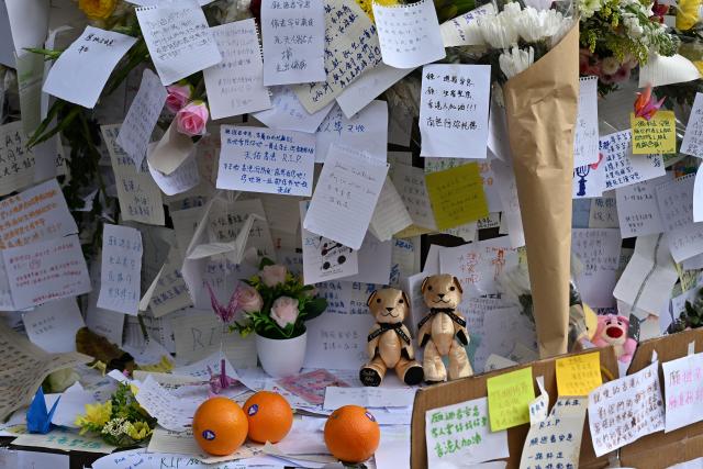 Flowers, messages and cuddly toys placed by mourners are seen at a makeshift memorial outside the Wang Fuk Court apartment blocks in the aftermath of the deadly November 26 fire in Hong Kong's Tai Po district on December 1, 2025. Police as well as Hong Kong's anti-corruption watchdog have launched investigations into the blaze that have killed at least 146 people, but a petition calling for greater accountability and demanding an independent probe was swiftly shut down as an organiser was reportedly arrested for sedition. (Photo by Peter PARKS / AFP)
