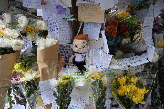 Flowers, messages and cuddly toys placed by mourners are seen at a makeshift memorial outside the Wang Fuk Court apartment blocks in the aftermath of the deadly November 26 fire in Hong Kong's Tai Po district on December 1, 2025. Police as well as Hong Kong's anti-corruption watchdog have launched investigations into the blaze that have killed at least 146 people, but a petition calling for greater accountability and demanding an independent probe was swiftly shut down as an organiser was reportedly arrested for sedition. (Photo by Peter PARKS / AFP)