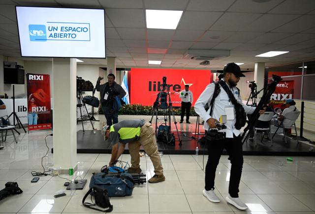 Journalists leave the headquarters of Honduran presidential candidate for the ruling Libertad y Refundacion (LIBRE) party Rixi Moncada, after the first results of the presidential election in Tegucigalpa on November 30, 2025. (Photo by Orlando SIERRA / AFP)