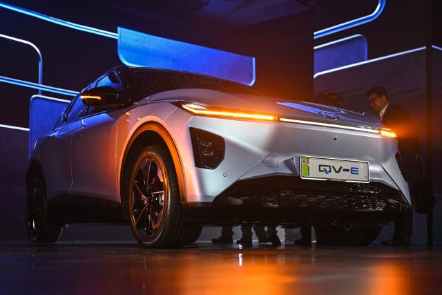 People look at Perodua's first EV car during a launch event in Kuala Lumpur on December 1, 2025. (Photo by Mohd RASFAN / AFP)