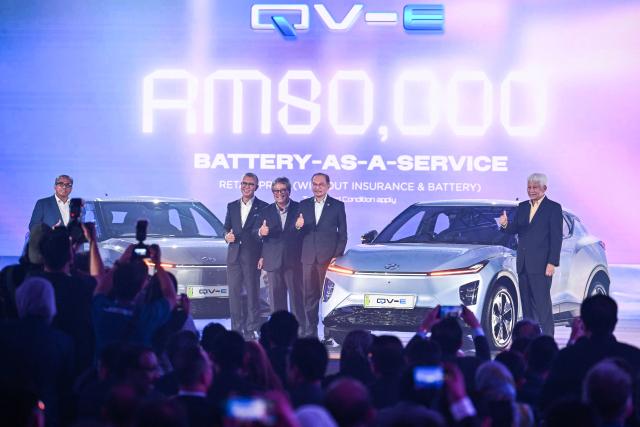 Malaysia's Prime Minister Anwar Ibrahim (2nd R) poses with Perodua's Chief Executive Officer Zainal Abidin Ahmad (3rd L) and Malaysia's Minister of Investment, Trade and Industry Tengku Zafrul (2nd L) next to Perodua's first EV car during a launch event in Kuala Lumpur on December 1, 2025. (Photo by Mohd RASFAN / AFP)