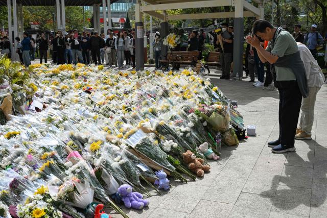 People lay flowers outside the Wang Fuk Court apartment blocks in the aftermath of the deadly November 26 fire in Hong Kong's Tai Po district on December 1, 2025. Police as well as Hong Kong's anti-corruption watchdog have launched investigations into the blaze that have killed at least 146 people, but a petition calling for greater accountability and demanding an independent probe was swiftly shut down as an organiser was reportedly arrested for sedition. (Photo by Peter PARKS / AFP)