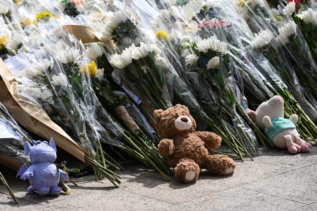Flowers and toys left by people are seen outside the Wang Fuk Court apartment blocks in the aftermath of the deadly November 26 fire in Hong Kong's Tai Po district on December 1, 2025. Police as well as Hong Kong's anti-corruption watchdog have launched investigations into the blaze that have killed at least 146 people, but a petition calling for greater accountability and demanding an independent probe was swiftly shut down as an organiser was reportedly arrested for sedition. (Photo by Peter PARKS / AFP)