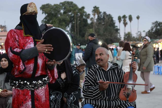 Musicians entertain the crowds hoping to win a few pennies in Jemaa el-Fna Square or Jamaa Lafna, listed as UNESCO Cultural Heritage site, located in the heart of the Medina of the city of Marrakech on November 30, 2025. (Photo by Abdel Majid BZIOUAT / AFP)