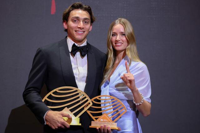 Sweden's world pole vault champion Armand Duplantis (L) holds his Men's World athlete of the year award and Men’s field athlete of the year award, as he poses with his partner Swedish model Desire Inglander (R), during the World Athletics Awards 2025 in Monaco, on November 30, 2025. (Photo by Valery HACHE / AFP)