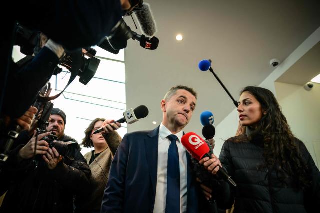 Mayor of Saint Etienne Gaël Perdriau (C) addresses media as he leaves after attending the summary proceedings of the trial of the sex-tape blackmail case at the courthouse in Lyon, central eastern France on December 1 2025. Perdriau announced his intention to appeal against his conviction today to five years in prison, of which four are custodial, in the case known as the sextape blackmail affair after Lyon court deliberated in the trial over the so-called "sex-tape" case of Saint-Etienne's town hall. At the heart of the trial is the mayor of the town, Gael Perdriau, 53, accused of ordering a video of his former deputy Gilles Artigues with a male prostitute, and tried alongside former associates for blackmail, criminal conspiracy and embezzlement of public funds. (Photo by OLIVIER CHASSIGNOLE / AFP)