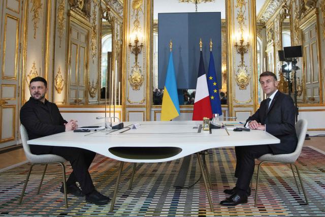 France’s President Emmanuel Macron (R) and his Ukrainian counterpart Volodymyr Zelensky pose prior to their meeting at the Elysee palace in Paris, on December 1, 2025. Ukrainian President Volodymyr Zelensky meets French counterpart Emmanuel Macron, seeking to shore up European support as US President expressed optimism of a deal to end Russia's war in Ukraine. (Photo by POOL / AFP)