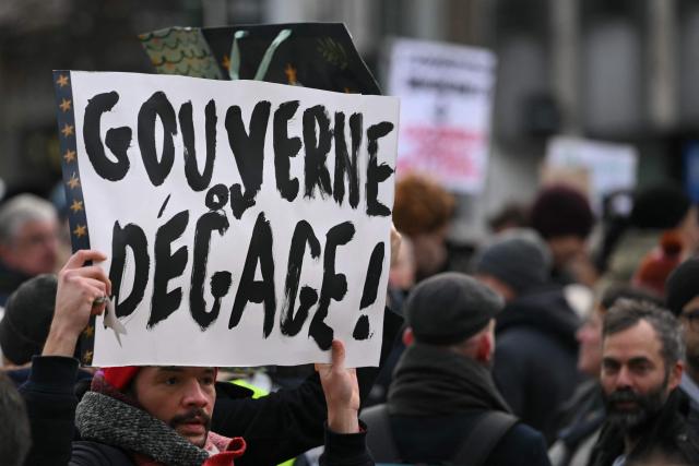 A man holds a placard reading "Rule or get out" as members of the collective "Respect Brussels" take part in a demonstration marking 541 days without a government, a world record, in Brussels on December 1, 2025. (Photo by NICOLAS TUCAT / AFP)