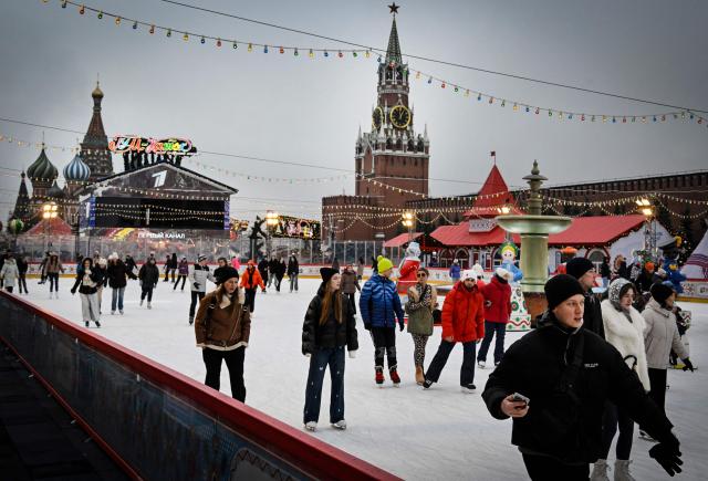 People enjoy skating at a temporary open air ice rink in the center of Red Square, with St. Basil's Cathedral (L) and the Kremlin's Spasskaya Tower (C) seen in the background, in Moscow on December 1, 2025. (Photo by Alexander NEMENOV / AFP)