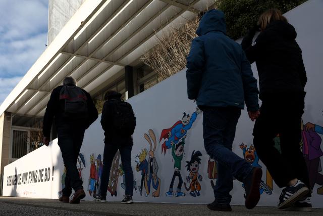 (FILES) Pedestrians walk in the street during the 52nd Angouleme International Comics Festival in Angouleme, on January 31, 2025. The 2025 edition of the Angouleme festival, scheduled for late January will not take place, one of the solicitors for the organising company 9e Art announced on December 1, 2025. (Photo by ROMAIN PERROCHEAU / AFP)