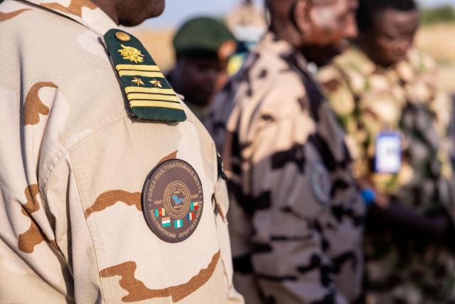 A Multinational Joint Task Force (MNJTF) patch is visible on a soldier's uniform during a visit to Lake Chad Province, Chad, on 26 November, 2025. The new commander-in-chief of the Multinational Joint Task Force (MNJTF) for counter-jihadist efforts in the Lake Chad Basin assured on Wednesday to AFP that securing waterways is a priority mission in this border region of Central Africa. Establishing secure navigation corridors is "one of the main priorities," according to General Saidou Tanko Audu, who has been leading the regional counter-jihadist force since mid-November. (Photo by Joris Bolomey / AFP)