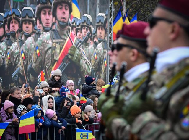 People watch Romanian Army forces during a military parade marking the National Day of Romania in Bucharest on December 1, 2025. (Photo by Daniel MIHAILESCU / AFP)