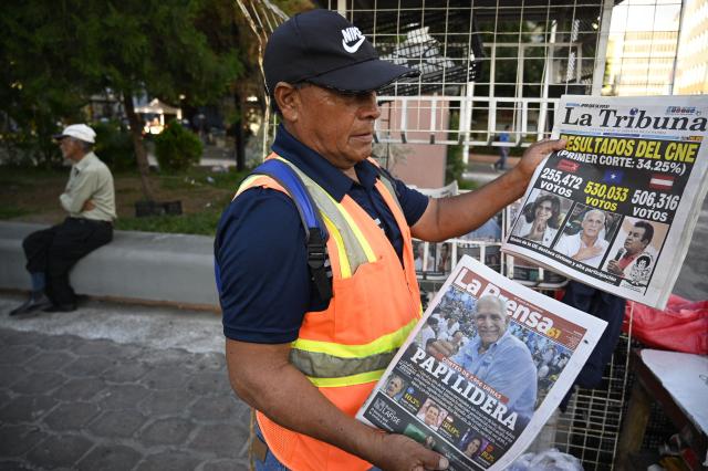 A man shows the front pages of newspapers as he offers them for sale in Tegucigalpa, on December 1, 2025, the day after the national election. Candidate Nasry Asfura, supported by US President Donald Trump, and his rival Salvador Nasralla, also from the right, are locked in a close race for victory in Honduras' presidential elections on Monday. (Photo by Orlando SIERRA / AFP)