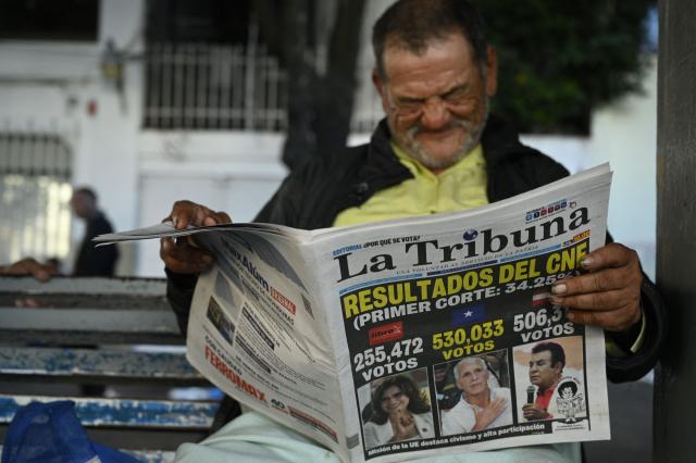 A man reads a newspaper in Tegucigalpa, on December 1, 2025, the day after the national election. Candidate Nasry Asfura, supported by US President Donald Trump, and his rival Salvador Nasralla, also from the right, are locked in a close race for victory in Honduras' presidential elections on Monday. (Photo by Orlando SIERRA / AFP)