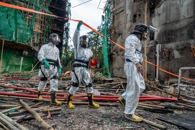 This handout photo released by the Hong Kong Police Force on December 1, 2025 shows officers from the Disaster Victim Identification Unit (DVIU) working after a deadly fire at the Wang Fuk Court residential estate in Hong Kong's Tai Po district. Authorities said on December 1 they have made a total of 13 arrests over Hong Kong's deadliest fire in decades after the blaze killed 151 people last week, a toll that could further rise. (Photo by HONG KONG POLICE FORCE / AFP)